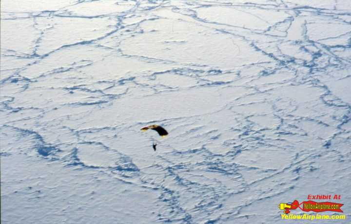 Picture of a skydiver jumping over the geographic north pole ice terrain.