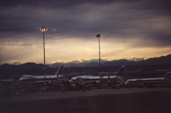 The sun rises over the passenger jets at the Milan Airport