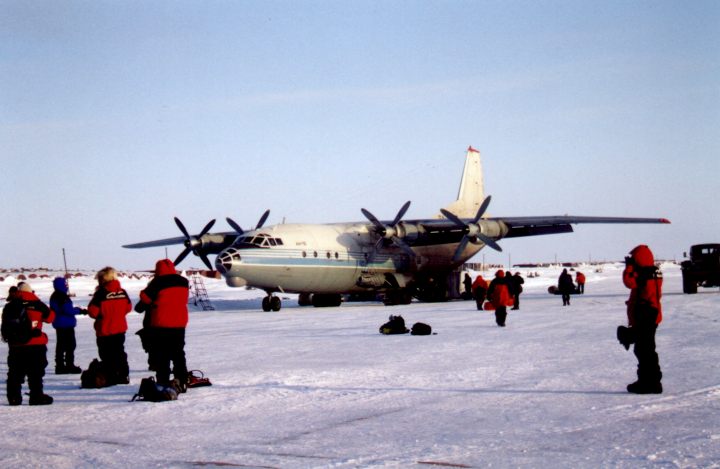 Expedition members stand in front of the Antonov 12 on Sredney Island