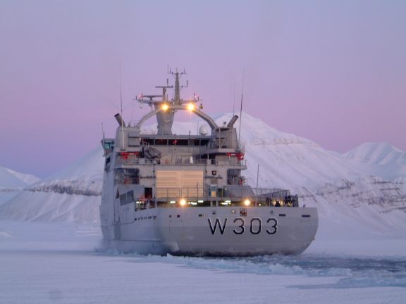 KV Svalbard breaking ice in the arctic ocean.