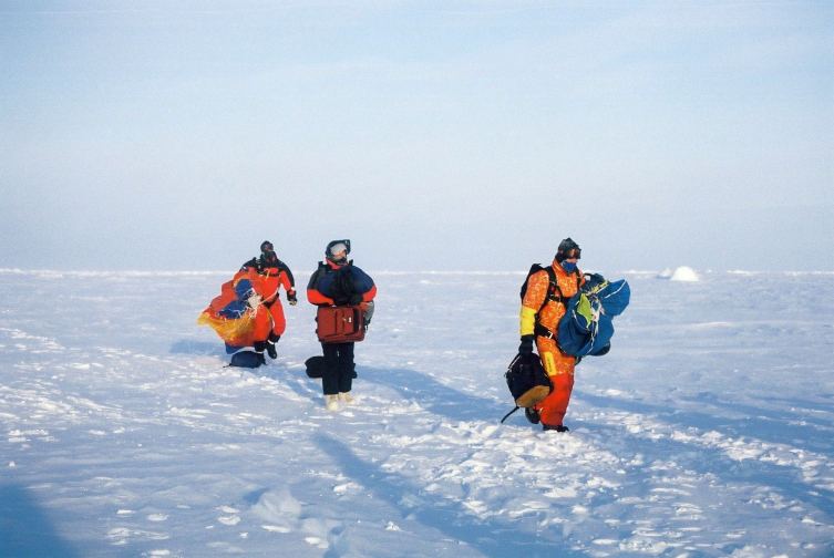 Anthony, Brian, and Burk walk back with their parachutes.