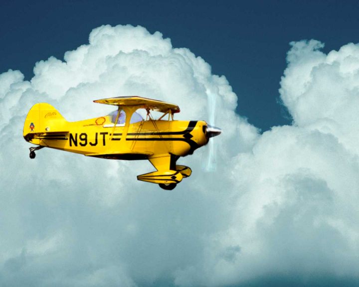 Jim Klick flying his Pitts Aerobatic Airplane high in the Clouds