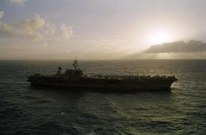 the sun rises and the uss kitty hawk is there