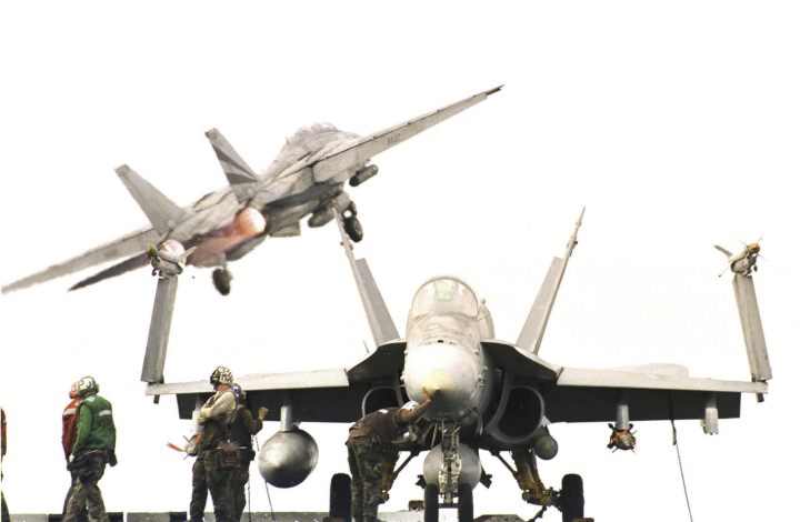 F-18 in the foreground, F-14 taking off of the catapult